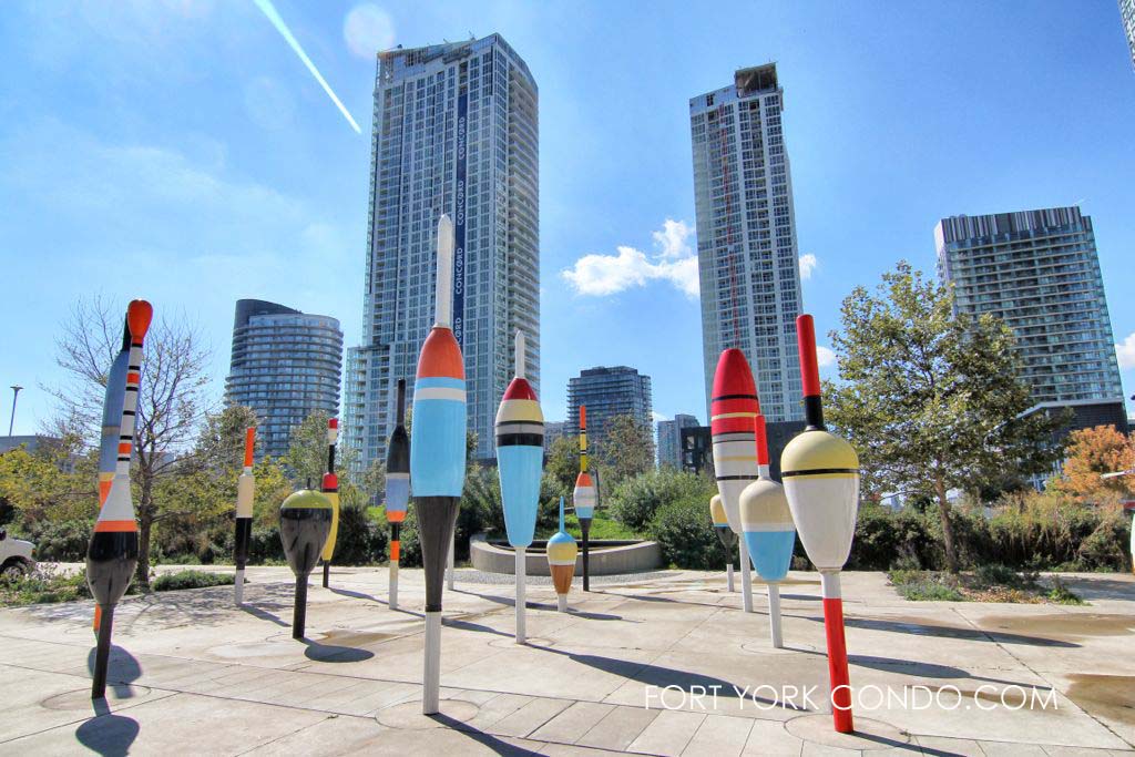 Large fishing bobbers at Canoe Landing Park with fort york condos in the background